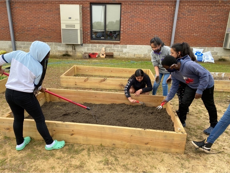 picture of students putting dirt in planters